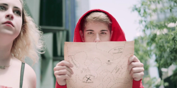 actor austin spero in character looking at a hand-drawn map